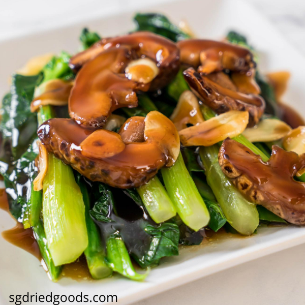 A plate of stir fry kale vegetables with mushrooms